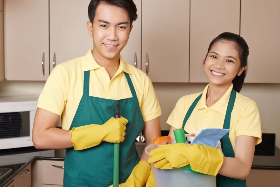 Man and woman cleaning and sanitising a food business