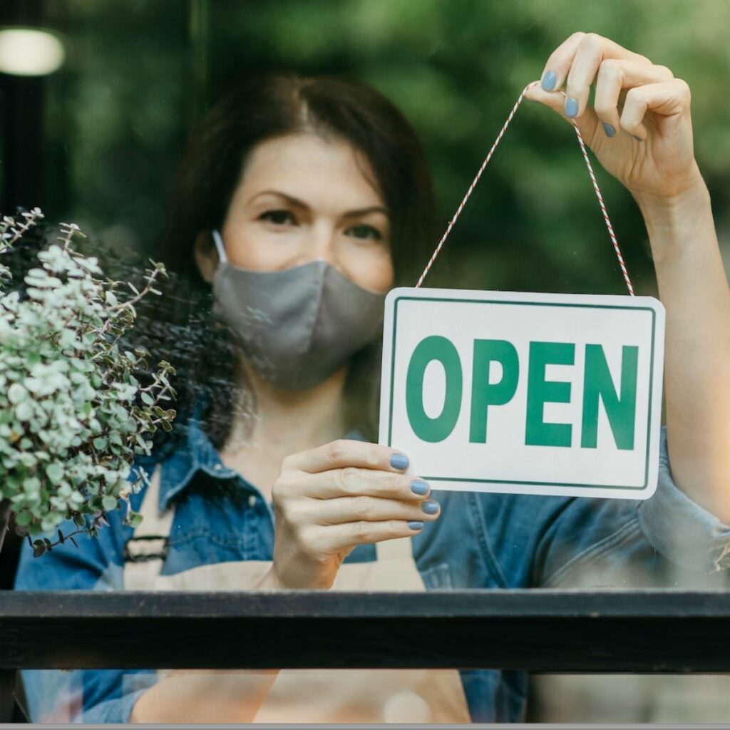 A food business owner opening her food outlet for contactless food service delivery and pick-up.